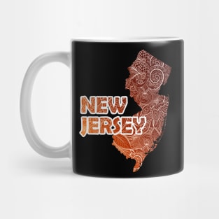 Colorful mandala art map of New Jersey with text in brown and orange Mug